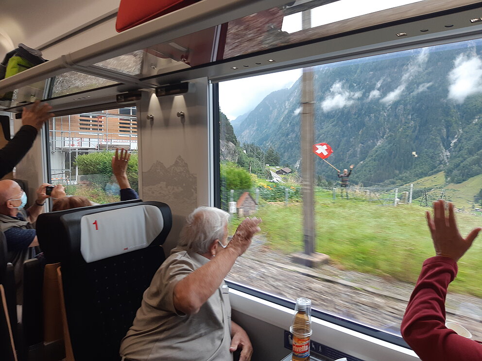 Wettbewerb-Bild: Fahrgäste winken dem Fahnenschwinger zu