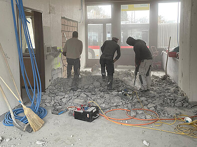 Die Bauarbeiter entfernen das Betonelement der alten Gepäckwaage.